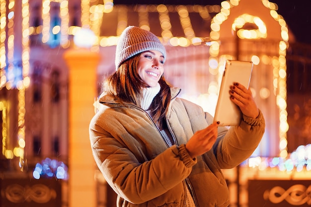 Belle jeune femme à l'aide de sa tablette numérique en hiver