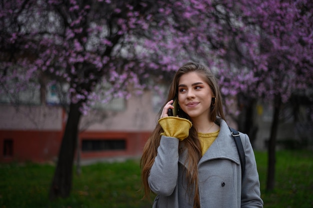 Belle jeune femme à l'aide d'un smartphone à l'extérieur