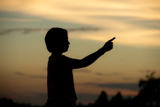 Belle jeune femme a l'air pleine d'espoir à ses mains au coucher du soleil.concept succès en main