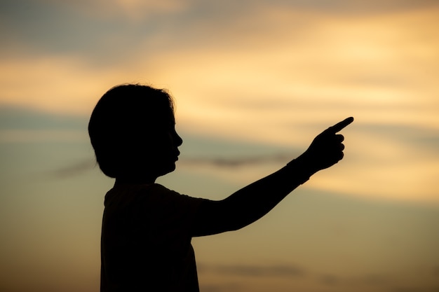 Belle jeune femme a l'air pleine d'espoir à ses mains au coucher du soleil.concept succès en main