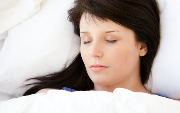 Photo belle jeune femme allongée dans un lit