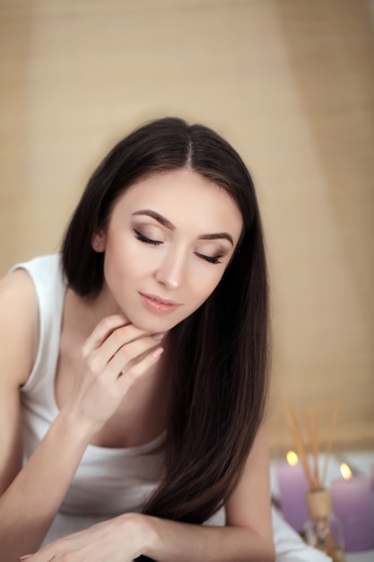 Belle jeune femme allongée sur une table de massage dans un salon spa