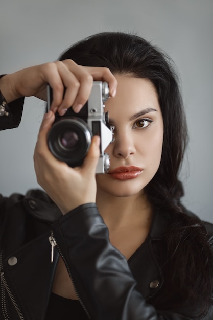 Belle jeune femme avec appareil photo à l'intérieur. Gros plan, portrait, de, hipster, élégant, jeune