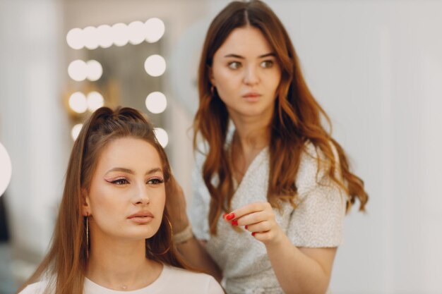 Belle jeune femme appliquant une brosse de visage de beauté de maquillage