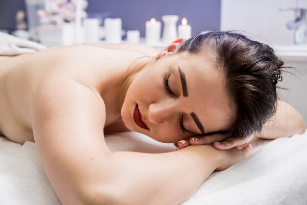 Belle jeune femme appréciant le massage dans le salon spa.