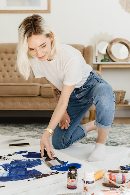 Belle jeune femme artiste dessinant dans un intérieur confortable