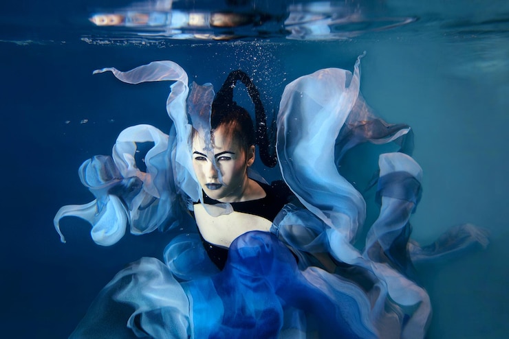 Photo belle jeune femme artistique dansant sous l'eau. sirène, danse, concept de fée