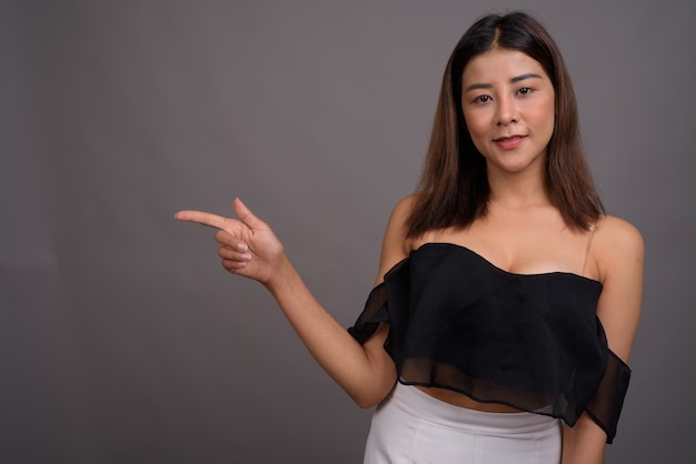 Belle jeune femme asiatique contre le gris