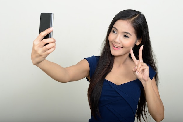 Belle jeune femme asiatique contre le mur blanc