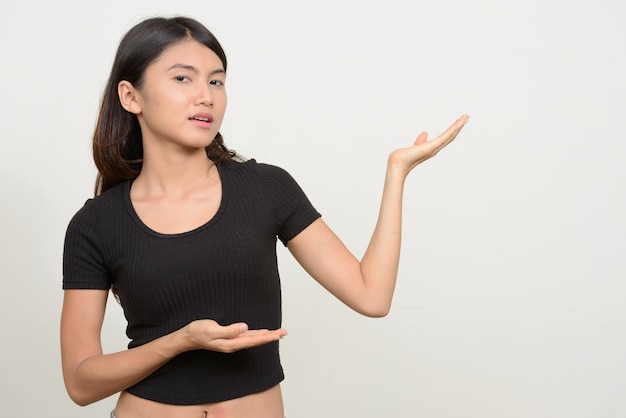 Belle jeune femme asiatique contre le mur blanc