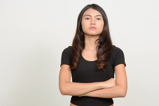 Belle jeune femme asiatique contre le mur blanc