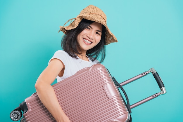 Belle jeune femme asiatique dans le concept de voyage de vacances, son sac valise étreignant