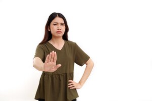Belle jeune femme asiatique debout tout en montrant un geste de la main d'arrêt ou de déni isolé sur blanc avec fond