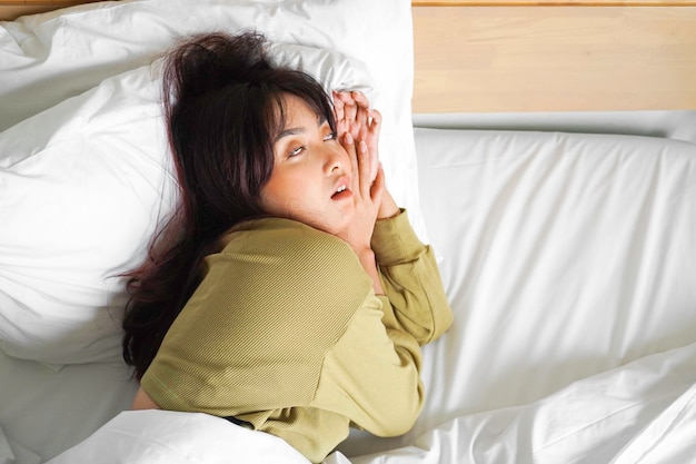 Belle jeune femme asiatique dormir dans son lit et se détendre le matin