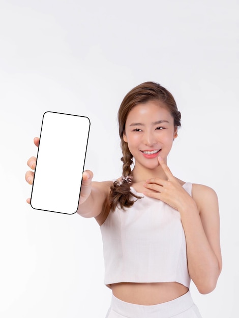 Photo belle jeune femme asiatique montrant un grand téléphone intelligent avec écran blanc écran blanc espace de copie vide pour bannière publicitaire isolée sur fond blanc mock up image