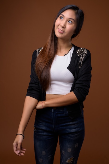 Belle jeune femme asiatique sur mur marron