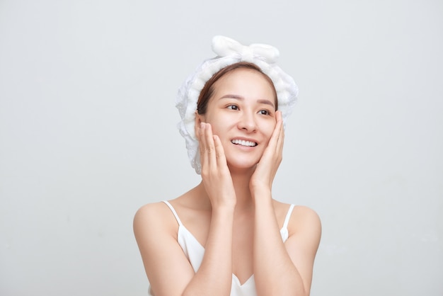 Belle jeune femme asiatique avec une peau parfaite isolée sur fond blanc.