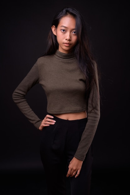Belle jeune femme asiatique portant un pull à col roulé