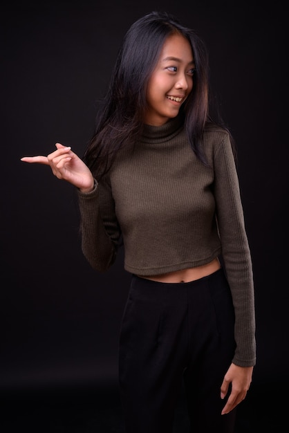 Belle jeune femme asiatique portant un pull à col roulé