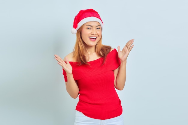 Belle jeune femme asiatique portant une robe de Noël montrant un visage joyeux et excité sur fond blanc