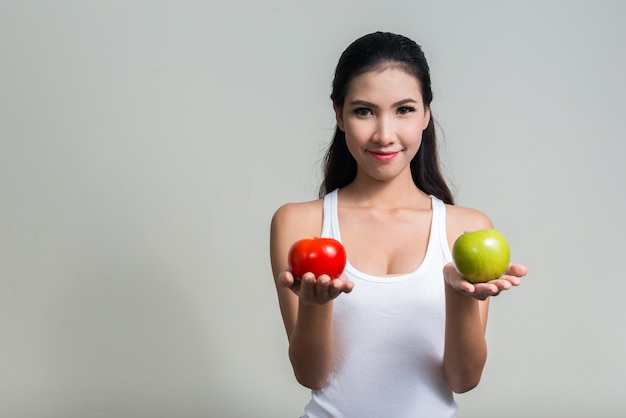 Belle jeune femme asiatique prête pour la salle de sport contre l'espace blanc