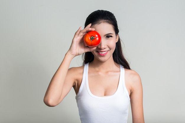 Belle jeune femme asiatique prête pour la salle de sport contre l'espace blanc