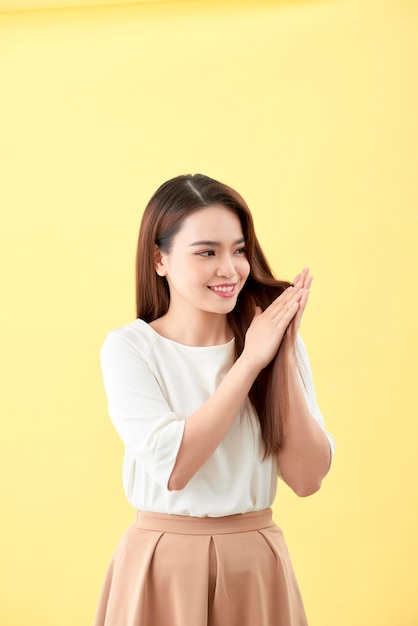 Belle jeune femme asiatique souriante et touchante lisser ses cheveux, maquillage naturel, visage de beauté, isolée sur fond bleu.