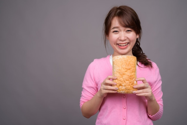 Belle jeune femme asiatique tenant un morceau de pain