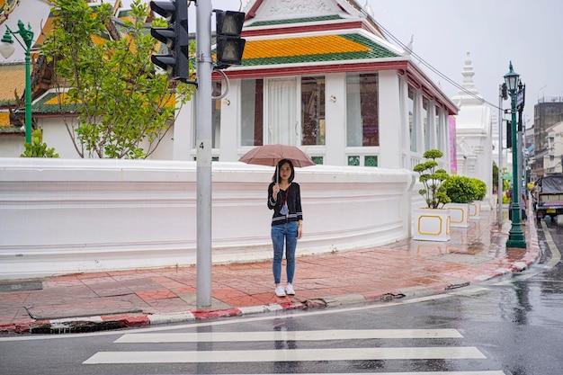 Belle jeune femme asiatique tenant un parapluie un jour de pluie