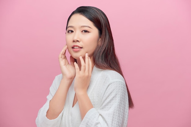 Belle jeune femme asiatique touchant le sourire doux de la joue avec une peau propre et fraîche Bonheur et gai avec une émotion positive