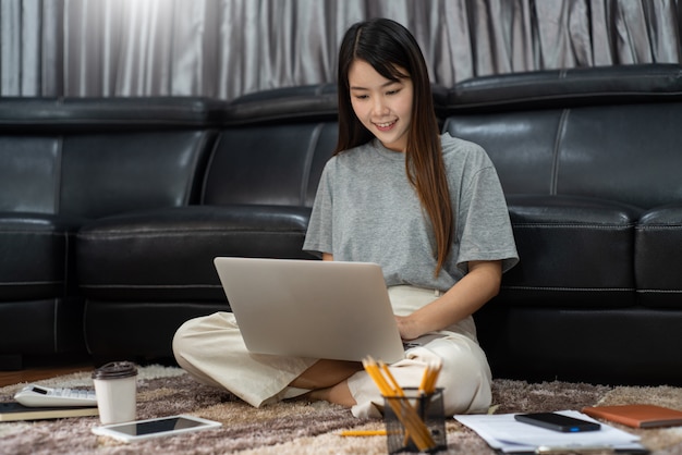 Belle jeune femme asiatique travaillant à la maison