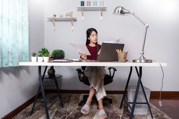 Belle jeune femme asiatique travaillant à la maison