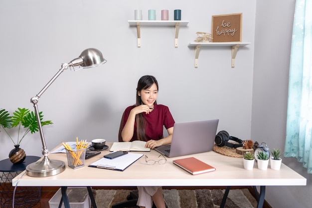 Belle jeune femme asiatique travaillant à la maison