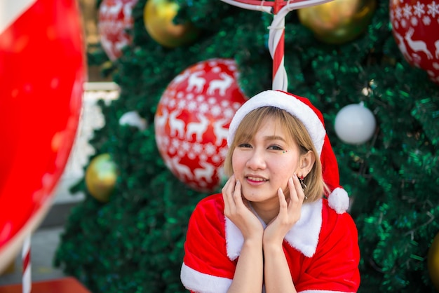 Belle jeune femme asiatique en vêtements de père Noël à l'extérieur