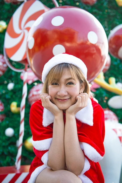 Belle jeune femme asiatique en vêtements de père Noël à l'extérieur