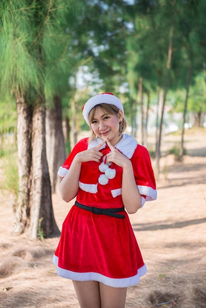 Belle jeune femme asiatique en vêtements de père Noël à l'extérieur