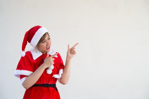 Belle jeune femme asiatique en vêtements de père Noël sur fond blancThaïlandaisEnvoyé du bonheur pour les enfantsJoyeux NoëlBienvenue à l'hiverconcept de femme heureuse