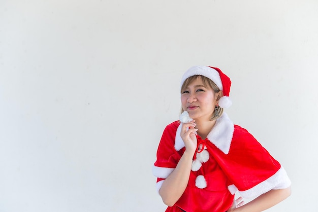 Belle jeune femme asiatique en vêtements de père Noël sur fond blancThaïlandaisEnvoyé du bonheur pour les enfantsJoyeux NoëlBienvenue à l'hiverconcept de femme heureuse
