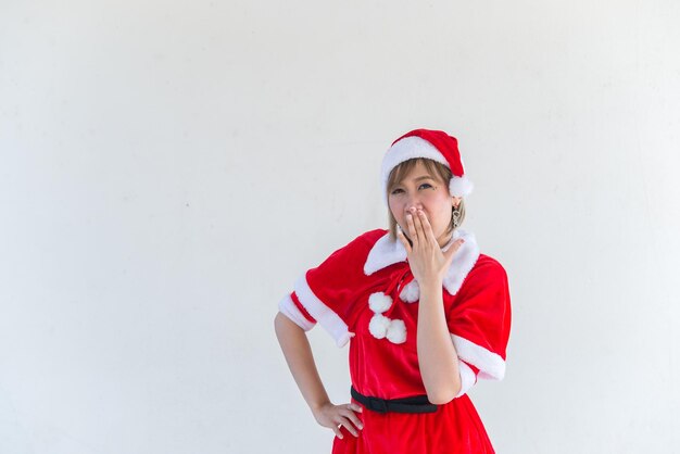 Belle jeune femme asiatique en vêtements de père Noël sur fond blancThaïlandaisEnvoyé du bonheur pour les enfantsJoyeux NoëlBienvenue à l'hiverconcept de femme heureuse