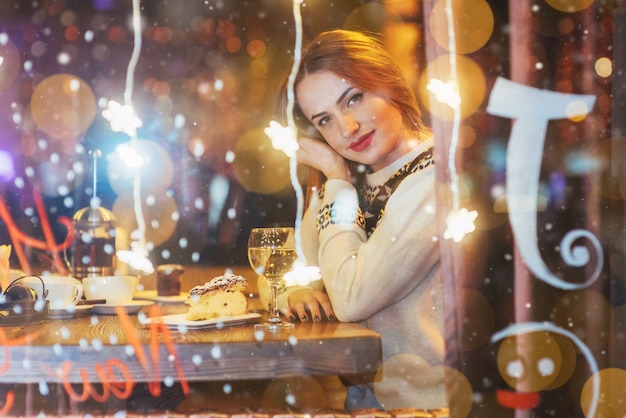 Belle jeune femme assise au café, boire du vin. Noël, nouvel an, Saint Valentin, vacances d'hiver