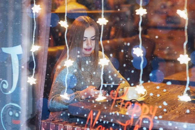 Belle jeune femme assise au café, buvant du café.