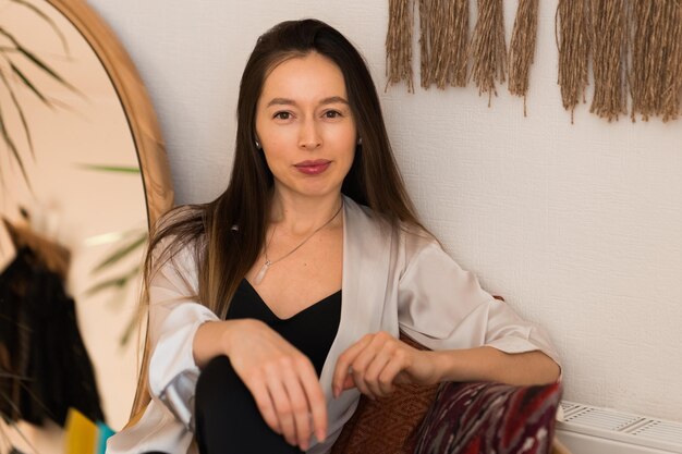 Belle jeune femme assise sur un banc à la maison concept de bien-être