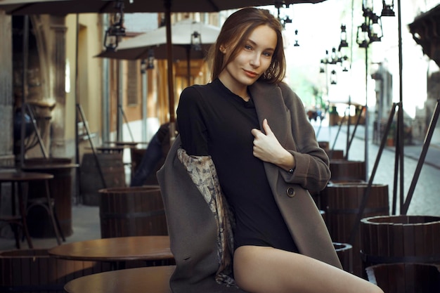 Belle jeune femme assise sur le bureau dans un café