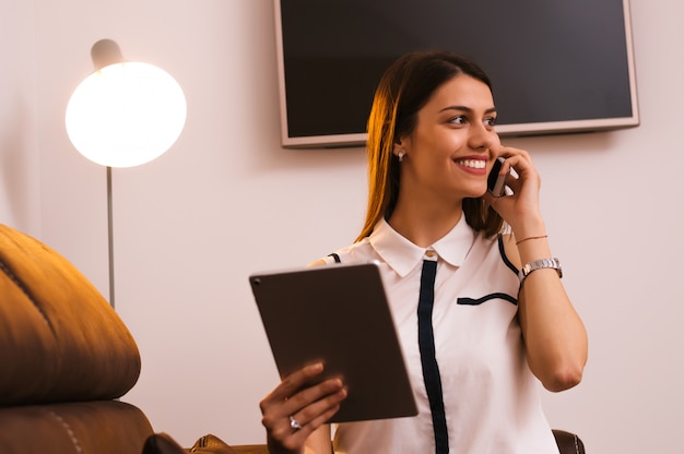 Belle jeune femme assise et parlant au téléphone