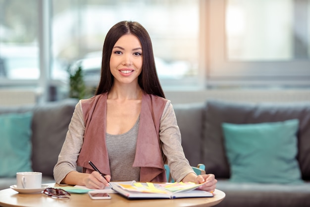 Belle jeune femme au café