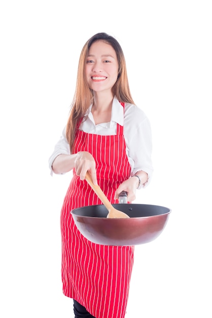 Belle jeune femme au foyer asiatique portant tablier rouge et tenant la casserole avec le sourire