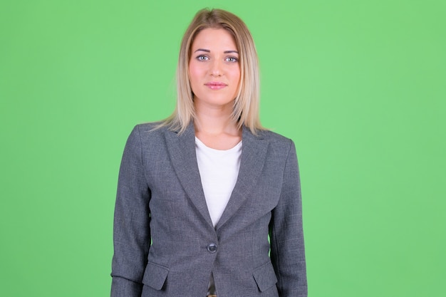 Belle jeune femme aux cheveux blonds contre la clé de chrominance sur vert