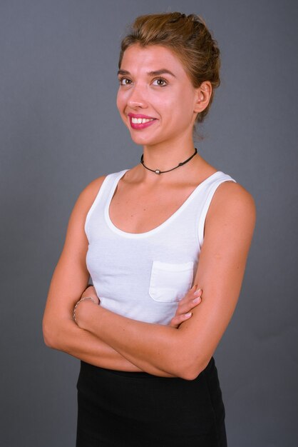 Belle jeune femme aux cheveux blonds sur fond gris