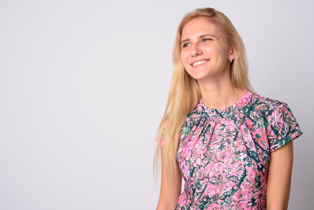 Belle jeune femme aux cheveux blonds portant une robe à fleurs