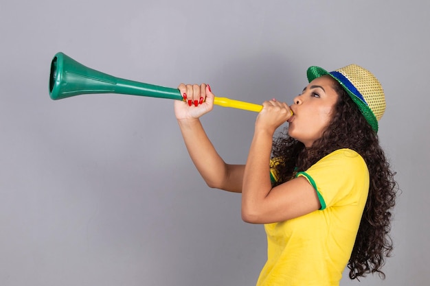 Photo belle jeune femme aux cheveux bouclés maquillée sur fond gris avec espace libre pour le texte